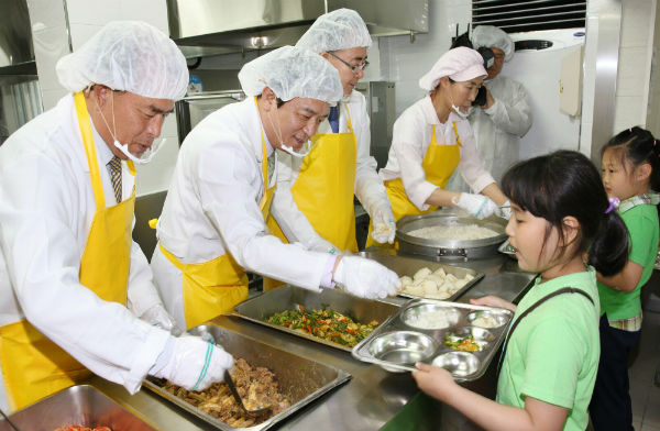 김병우(왼쪽 두 번째) 충북도교육감이 28일 청주 한솔초등학교 식생활관에서 무상급식 운영 실태를 점검하고 학생들에게 배식을 하고 있다.