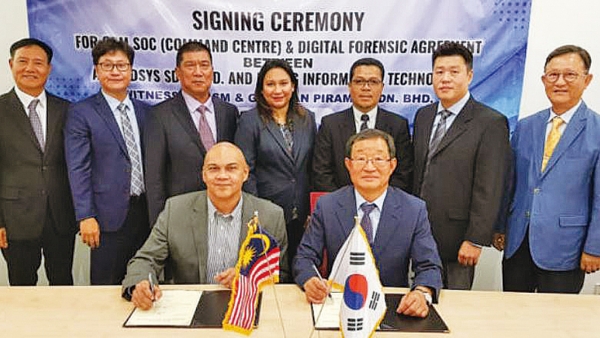 이명재 명정보기술 대표(앞줄 오른쪽)와 말레이시아 사이버보안청 보안관제센터 구축업체 아센시스의 모하메드 시합 대표가 7월 24일 협약서에 서명하고 있다.