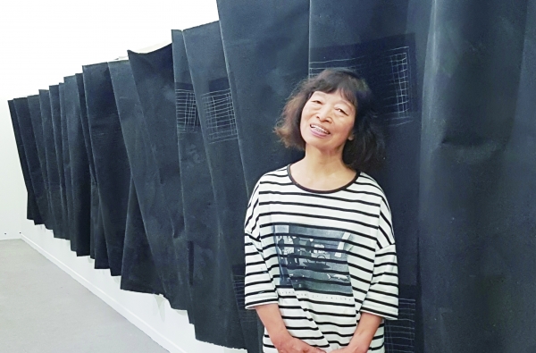 청주시립미술관에 전시된 자신의 작품 ‘밤의 심연’ 앞에 선 김주영 화가.