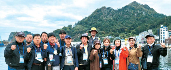 동양일보 제천기획위원들이  울릉도 저도항에서 기념 사진 촬영을 하고 있다.