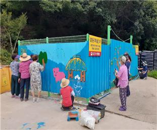 보은군 회인면 용촌2리 주민들이 마릉 입구에 자리한 폐비닐 수거장에 벽화그리기 공동작업을 하고 있다.
