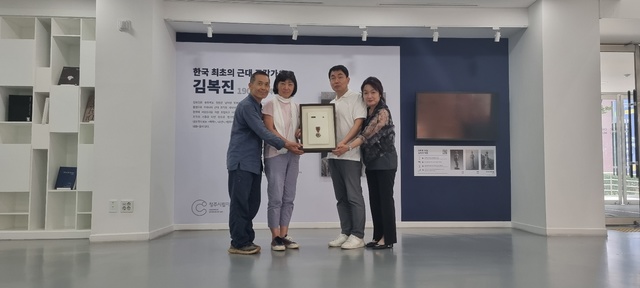 정창훈 조각가와 청주미협관계자, 유족대표가 김복진 훈장을 청주시립미술관에 기증하고 있다.