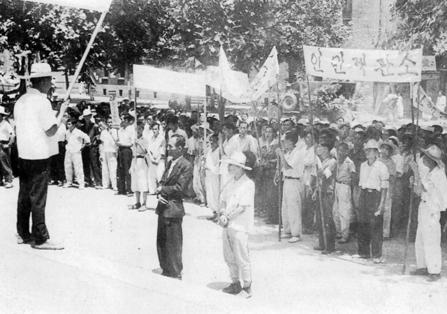 구 국회의사당 앞에서 인민재판을 받는 팔봉. 앞에 검은 옷을 입은 사람(1950년)