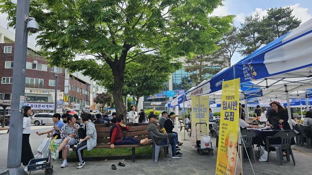 청소년광장 나무 그늘 아래 벤치에서 휴식을 취하는 청주시민들.
