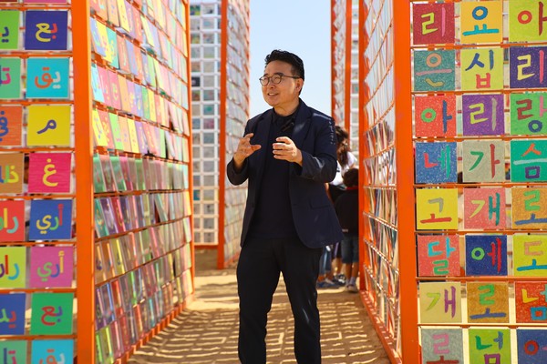 이집트 피라미드 앞에 세운 한글신전 앞에서 강익중이 작품설명을 하고 있다.   강익중스튜디오/이앤아트 제공