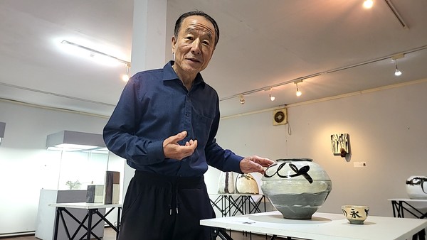 유영문 촌장이 전시장에 선보인 자신의 작품과 도자예술촌의 미래에 대해 설명하고 있다