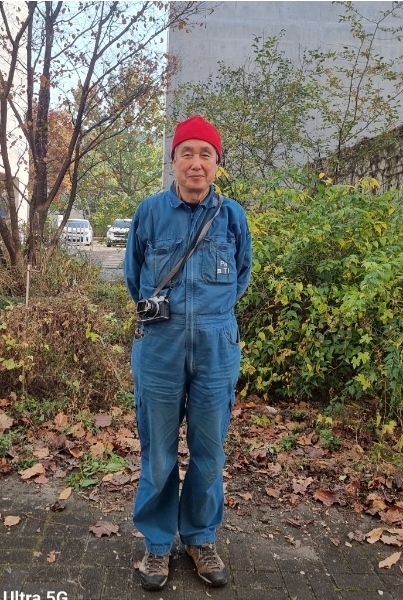 트레이드 마크인 점프수트와 빨간 비니