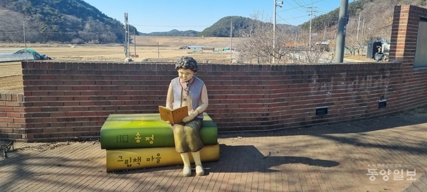 송정그림책마을 입구에 책 읽는 주민상이 보인다. 