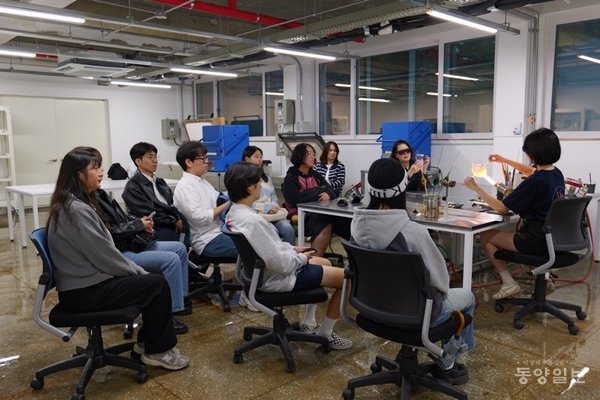 ▲원데이클래스 참여자들이 유리공예 램프워킹 시연을 참관하고 있다.