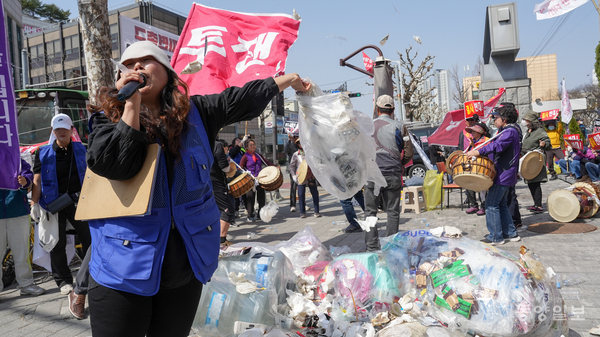26일 충북도청에서 현도면 주민들이 집회를 열어 청주시가 현도산업단지에 추진하는 재활용 선별센터에 대한 전면 백지화를 촉구하며 쓰레기를 흩뿌리는 퍼포먼스를 하고 있다.[사진=손상훈 기자]