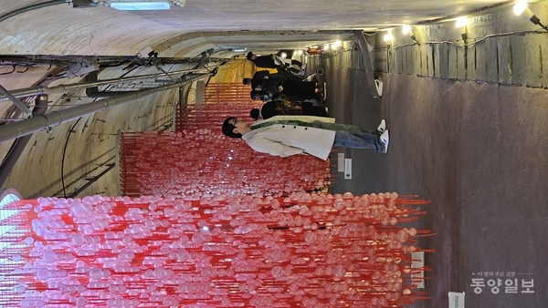 최성임 작가의 플라스틱 망, 공을 담아 직조한 붉은색 중앙통로 설치 작품 ‘Holes 구멍들’