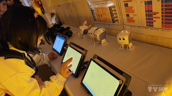 주말 특별 프로그램으로 준비된 로봇체험전시존에서 아이들이 태블릿으로 로봇을 움직여 보고 있다.
