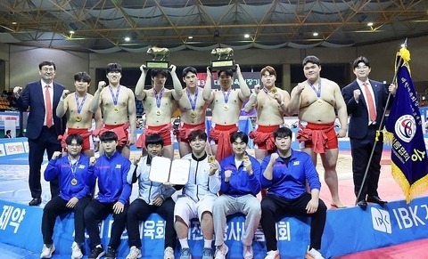 14일 전남 보성군 다양체육관에서 열린 '3회 대한체육회장기장사씨름대회' 대학부 단체전 우승을 차지한 단국대(충남) 선수들이 주두식 감독(왼쪽) 및 임대혁 코치(오른쪽)와 함께 기념 촬영하고 있다. 대한씨름협회 제공.