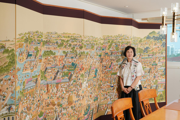 ▲지난해 한국전통민화협회 전국공모전에서 국회의장상을 받은 조태정 작가가 자신의 작품 '태평성시도' 앞에서 포즈를 취하고 있다.