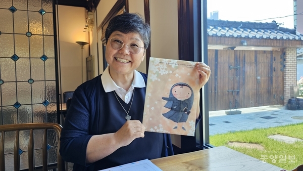 ▲송은주 모퉁잇돌 원장수녀가 입소 아이들이 작업한 일러스트를 자랑스럽게 내보이고 있다.