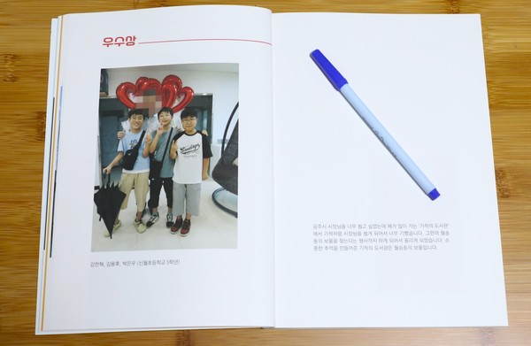 신월초 5학년 강전혁 김용후 박은우 군 3명의 공동 작품이 실린 도록의 우수상 페이지. 왼쪽 페이지 사진의 가운데 뒤에 최원철 시장이 아이들을 끌어 안는 모습으로 서 있는데 모자이크 처리를 한 상태로 인쇄돼 누군지 알수가 없다.