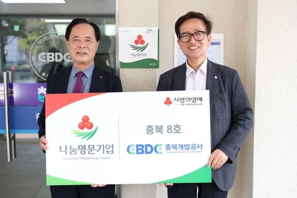 진상화(오른쪽) 충북개발공사 사장이  지난 4월 '나눔명문기업' 현판식 후 기념촬영하고 있다.