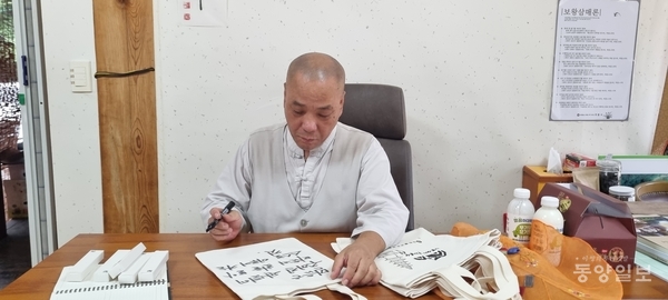정덕 무량사 주지스님이 법문을 쓰고 있다.