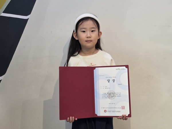 지이안 어린이가 상장을 들고 기념촬영하고 있다.