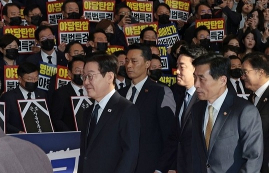 이재명 대통령이 4일 내년도 정부 예산안에 대한 시정연설을 하기 위해 서울 여의도 국회에 도착해 피켓시위를 하는 국민의힘 의원들 앞을 지나고 있다. 국민의힘 의원들은 추경호 전 원내대표에 대한 내란특검팀의 영장청구에 반발하며 야당 탄압 중단을 촉구했다.