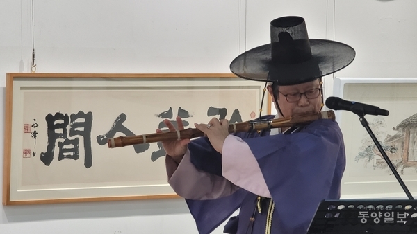 ▲13일 오후 3시 청주예술의전당 대전시실에서 열린 청주문화원 주최 2회 청주시민소장전 '빗장, 열다' 개전식 축하공연에서 박노상 대금연주자가 연주하고 있다.