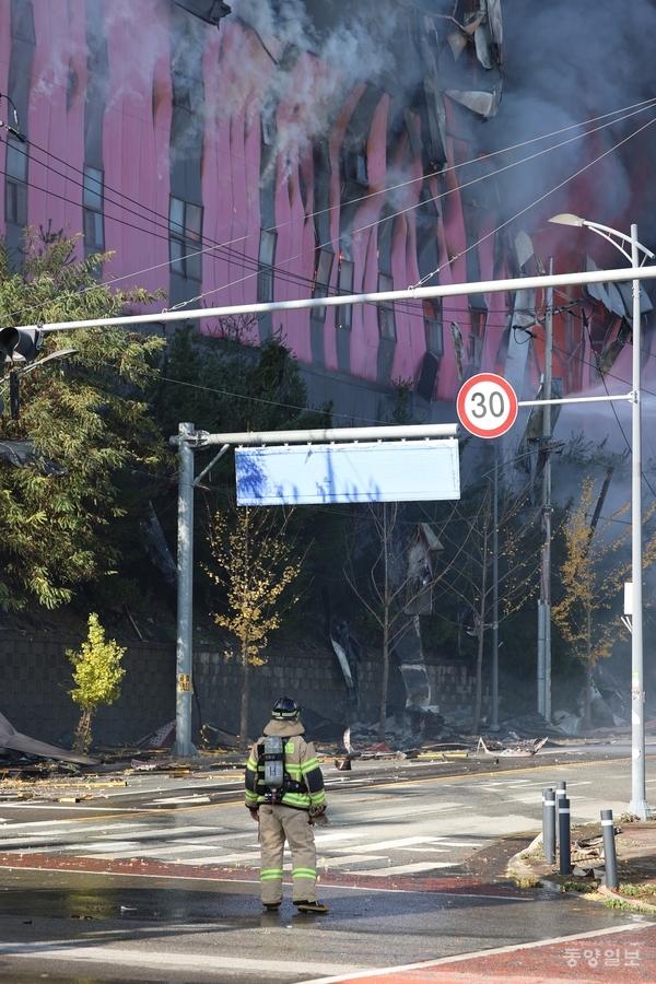 15일 오전 11시께 충남 천안시 동남구 풍세면 이랜드패션 물류센터 화재현장에서 한 소방관이 화재현장을 바라보고 있다.[사진=조창희 기자]