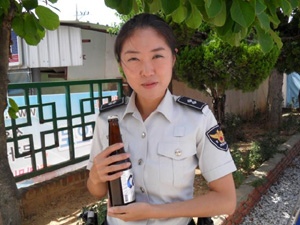 김선미 순경이 노인으로부터 선물받은 맥주한병을 들고 기념촬영을 하고 있다.