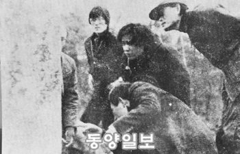 1979년 2월 24일 ‘고구려비’로 밝혀진 입석리 비를 다시 찾은 예성동호회원들이 비문을 들여다 보며 판독을 하고 있다. 가운데가 필자, 모자 쓴 이가 김풍식씨다.
