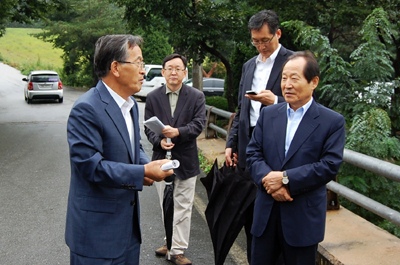 임각수(왼쪽) 군수가 충북과 경북 경계지역에서 박인주(오른쪽) 청와대 사회통합수석에게 행정구역의 불합리성을 설명하고 있다.